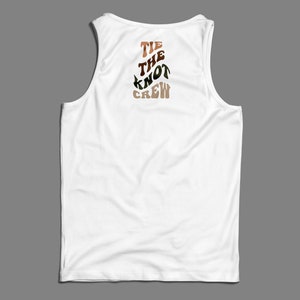 May include: White tank top with the text "TIE THE KNOT CREW" printed on the back in brown, orange, and green.