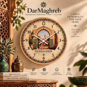 May include: A round wall clock featuring a central illustration of a Moroccan archway with palm trees and a tower. The clock face has black Arabic numerals, white hands, and a decorative border with geometric patterns in red, green, and blue.