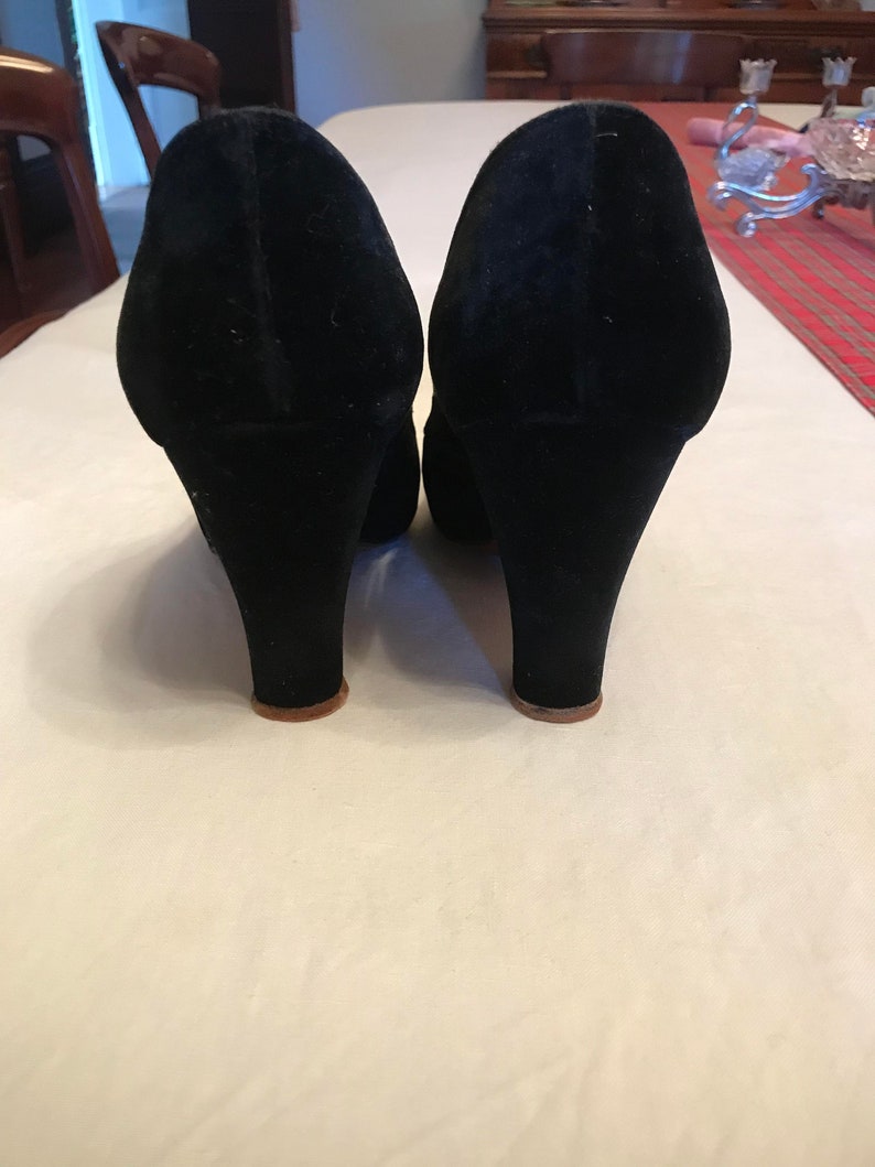 K&ouml;nnte beinhalten: Ein Paar schwarze Wildlederschuhe mit geschlossenem Zeh und einem dicken Absatz.