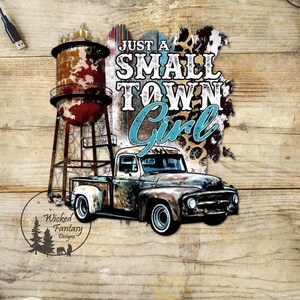 May include: A rustic design featuring a water tower and a vintage pickup truck. The text reads "Just a Small Town Girl" in a mix of fonts and colors. The design has a distressed, weathered look, with a wooden background.