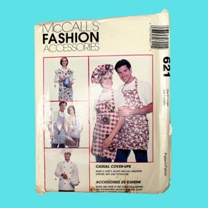 May include: A sewing pattern for making kitchen accessories, including a chef's jacket, hat, aprons, a mitt, and a potholder. The pattern is called "Casual Cover-Ups" and is from McCall's Fashion Accessories. The pattern number is 621.