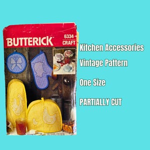 May include: Vintage Butterick Craft pattern number 6334 for kitchen accessories. The pattern is partially cut and includes instructions for making a pot holder, a hot pad, and a jar cover. The pattern features a blue and white gingham design with a chicken motif.