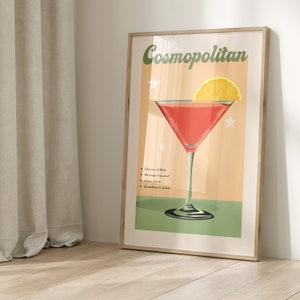May include: A vintage-style poster featuring a red Cosmopolitan cocktail in a martini glass. The poster has a peach background with green accents and the text "Cosmopolitan" in a retro font. The ingredients are listed below the glass: citrus vodka, orange liqueur, lime juice, and cranberry juice.