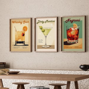 May include: Three framed vintage-style cocktail posters with illustrations of a Whiskey Sour, a Dirty Martini, and a Negroni. Each poster includes the drink's name, ingredients, and instructions.