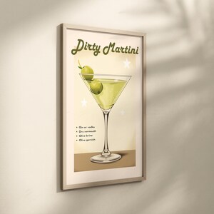 May include: A vintage-style illustration of a Dirty Martini cocktail with green olives. The text "Dirty Martini" is written in a retro font at the top of the image. The ingredients are listed below: Gin or Vodka, Dry Vermouth, Olive Brine, Olive Garnish.