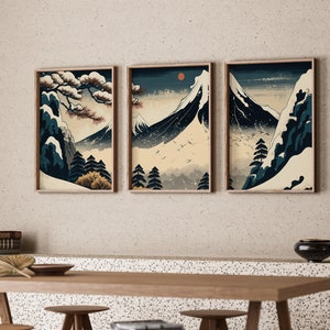 May include: Three framed prints depicting a Japanese mountain scene with snow-capped peaks, a pine tree, and a red sun in the sky. The prints are in a minimalist style with muted colours.