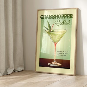 May include: A vintage-style poster advertising a Grasshopper Cocktail. The poster features a green cocktail in a martini glass with a sprig of mint and a red cherry. The text on the poster reads "Grasshopper Cocktail" and lists the ingredients: Cr&egrave;me de menthe, Cr&egrave;me de cacao, and Heavy cream.