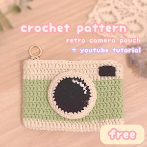 May include: Crocheted retro camera pouch in cream and green, featuring a large black lens and a small black square. The text "crochet pattern" and "retro camera pouch + youtube tutorial" are visible. A gold-colored zipper pull is attached.