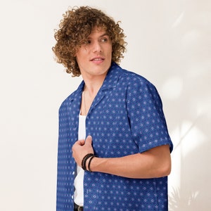 May include: A blue short-sleeved shirt with a white background and a pattern of small, repeating stars of David.