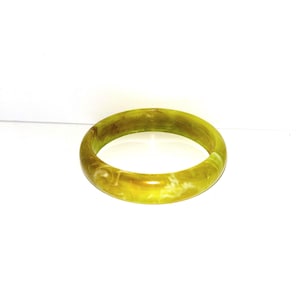 May include: A round, olive-green bangle bracelet with a marbled appearance. The bracelet is made of a solid material and has a smooth, polished finish. The color is a mix of yellow and green.