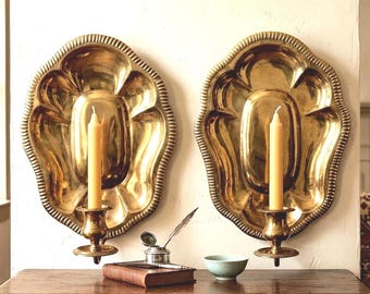 Pair of Cottagecore ornate brass golden patina taper candle holder wall sconces featuring stylized leaf-shaped wall plates.