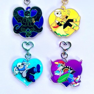 May include: Four colorful heart-shaped acrylic keychains featuring different characters from the video game Undertale. The keychains are attached to silver and gold metal heart-shaped clasps.