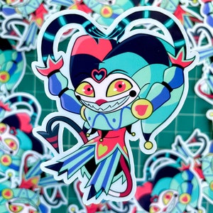 May include: A sticker featuring a cartoon jester with a red, blue, and yellow costume. The jester has a wide grin and large, red eyes. The sticker is on a green background.