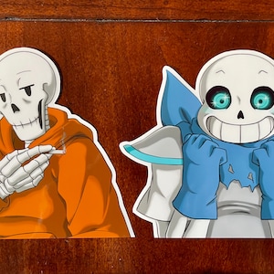 May include: Two cartoon skeleton characters, one in an orange hoodie and the other in a blue scarf, are depicted in a sticker format. The skeleton in the orange hoodie is holding a cigarette in its hand. The skeleton in the blue scarf has bright blue eyes and a wide smile.