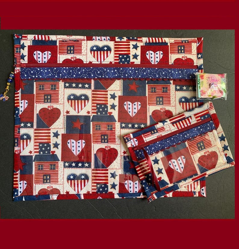 Pode incluir: Um conjunto de duas bolsas com z&iacute;per de tem&aacute;tica patri&oacute;tica. A bolsa maior apresenta um padr&atilde;o repetido de cora&ccedil;&otilde;es, casas e bandeiras americanas em vermelho, branco e azul. A bolsa menor espelha o design. Ambas t&ecirc;m z&iacute;peres e acabamentos azuis.