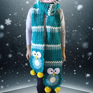 May include: A teal blue crocheted scarf with white stripes and two owl appliques. The owls have white eyes, yellow beaks, and yellow pom-poms.