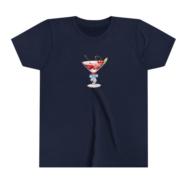 Peut inclure: T-shirt bleu marine avec une illustration &agrave; l'aquarelle d'un verre &agrave; cocktail rempli de cerises. Le verre est orn&eacute; d'un ruban bleu clair nou&eacute; autour de la tige. Les cerises sont rouges et la boisson est rose.