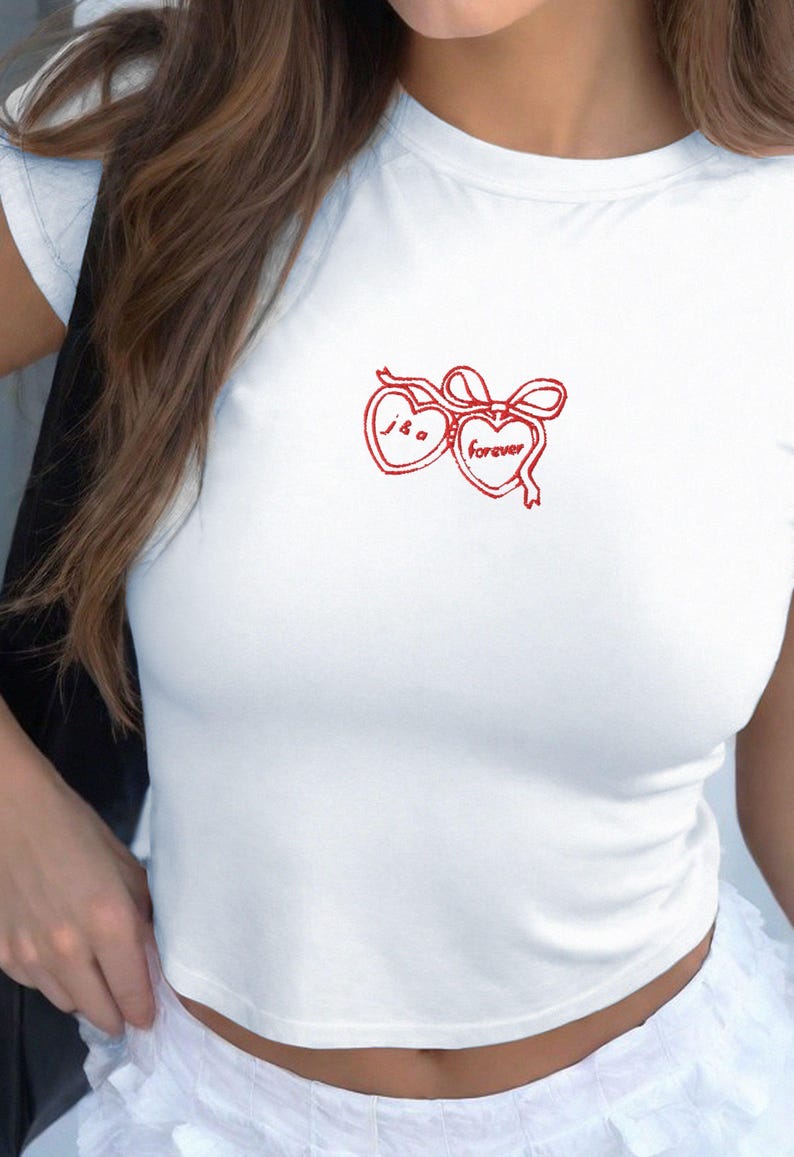 May include: White cropped t-shirt with a red embroidered design of two hearts with a bow. The hearts have the text "J & G" and "forever" inside.