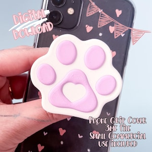 May include: A white and pink paw print phone grip cover with a heart-shaped cutout. The phone case has a black background with pink hearts and a banner design. Text includes "Digital Download" and "Phone Grip Cover 3MF File Small Commercial Use Included."