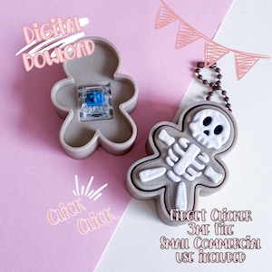 May include: A gray gingerbread man-shaped fidget clicker with a white skeleton design. The clicker is attached to a chain and has the text "Fidget Clicker 3MF File Small Commercial Use Included". The image also includes the text "Digital Download" and "Click Click".