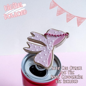 Può includere: Un apribottiglie a forma di fiocco rosa e marrone con pois bianchi, appoggiato su una lattina di soda rossa. L'immagine include il testo "Digital Download" e "Soda Can Opener 3MF File Small Commercial Use Included."