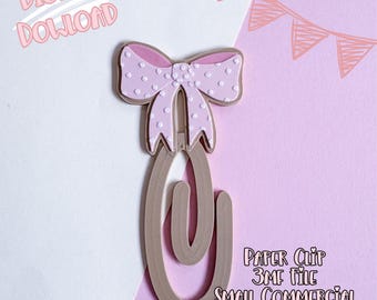 May include: A paper clip with a pink bow featuring white polka dots. The paper clip is a light brown color. The words "DIGITAL DOWNLOAD" and "PAPER CLIP 3MF FILE SMALL COMMERCIAL USE INCLUDED" are written on the image.