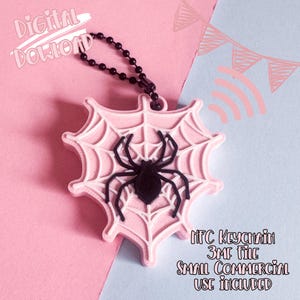 Könnte beinhalten: Ein rosa schlüsselanhänger in Spinnennetzform mit einer schwarzen Spinne in der Mitte. Der Schlüsselanhänger ist an einer schwarzen Kugelkette befestigt. Der Text auf dem Bild lautet "Digitaler Download" und "NFC-Schlüsselanhänger 3MF-Datei Kleine kommerzielle Nutzung inklusive."