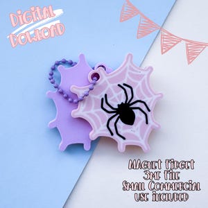 Pode incluir: Um fidget magnético em forma de teia de aranha rosa e roxo claro com uma aranha preta no centro. O fidget está preso a um pingente roxo claro. O texto na imagem diz "Digital Download" e "Magnet Fidget 3MF File Small Commercial Use Included."