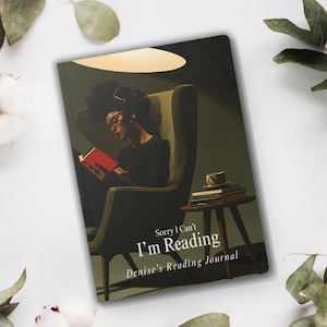 May include: A rectangular reading journal with a dark green cover featuring an illustration of a person in a high-backed chair reading a red book. The text reads Sorry I Can't I'm Reading and Denise's Reading Journal in white font.