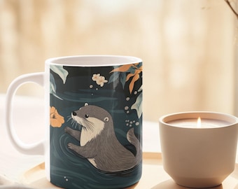 Può includere: Tazza in ceramica bianca con l'illustrazione di una lontra grigia che nuota in acqua blu scuro con fiori arancioni e bianchi. La tazza ha un manico bianco ed è appoggiata su un vassoio di legno accanto a una candela accesa.
