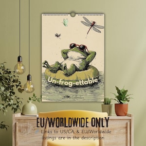 May include: A 2026 calendar featuring a relaxed frog wearing sunglasses and floating on an inner tube. The calendar has the text "Un-frog-ettable" and includes illustrations of dragonflies and butterflies. The calendar is for EU/Worldwide.
