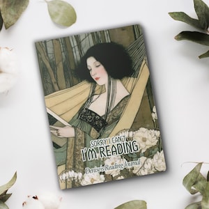 May include: A rectangular reading journal featuring an illustration of a person with dark hair resting in a hammock, surrounded by white flowers. The text reads SORRY I CAN'T I'M READING and Denise's Reading Journal in a decorative font.