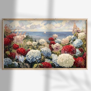 May include: A framed floral painting featuring a vibrant display of red, white, and blue hydrangeas in the foreground. The background depicts a serene seascape with a sailboat under a cloudy sky. The artwork is encased in a light brown wooden frame.