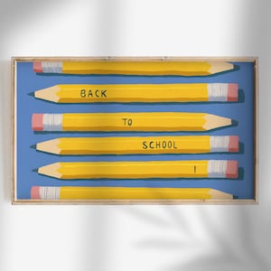 Puede incluir: Impresión enmarcada con seis lápices amarillos con gomas rosas y la frase "BACK TO SCHOOL" sobre un fondo azul. Los lápices están dispuestos horizontalmente, creando un tema de regreso a clases.