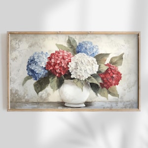 Può includere: Dipinto incorniciato di un vaso bianco pieno di ortensie rosse, bianche e blu. I fiori sono circondati da foglie verdi. Lo sfondo è strutturato e di colore bianco sporco.