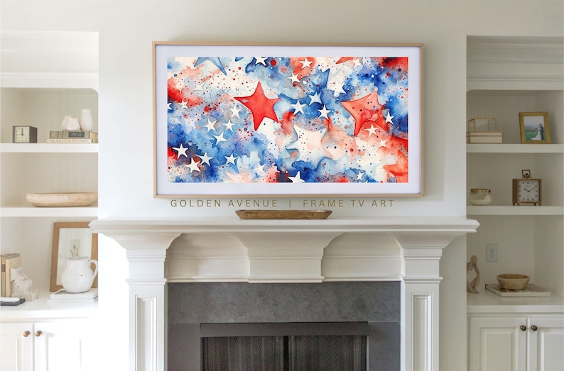 May include: A watercolor painting of a red, white, and blue American flag with stars. The stars are painted in a loose, abstract style. The painting is framed in a gold frame and is hanging above a fireplace.