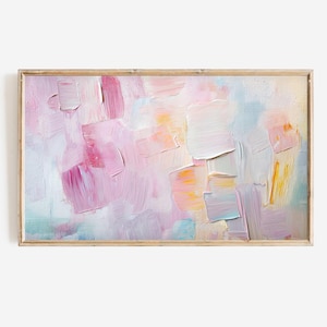 May include: Abstract oil painting in a wooden frame. The artwork features thick brushstrokes in shades of pink, white, and yellow, with hints of blue and green. The painting has a textured appearance, creating a modern and artistic aesthetic.