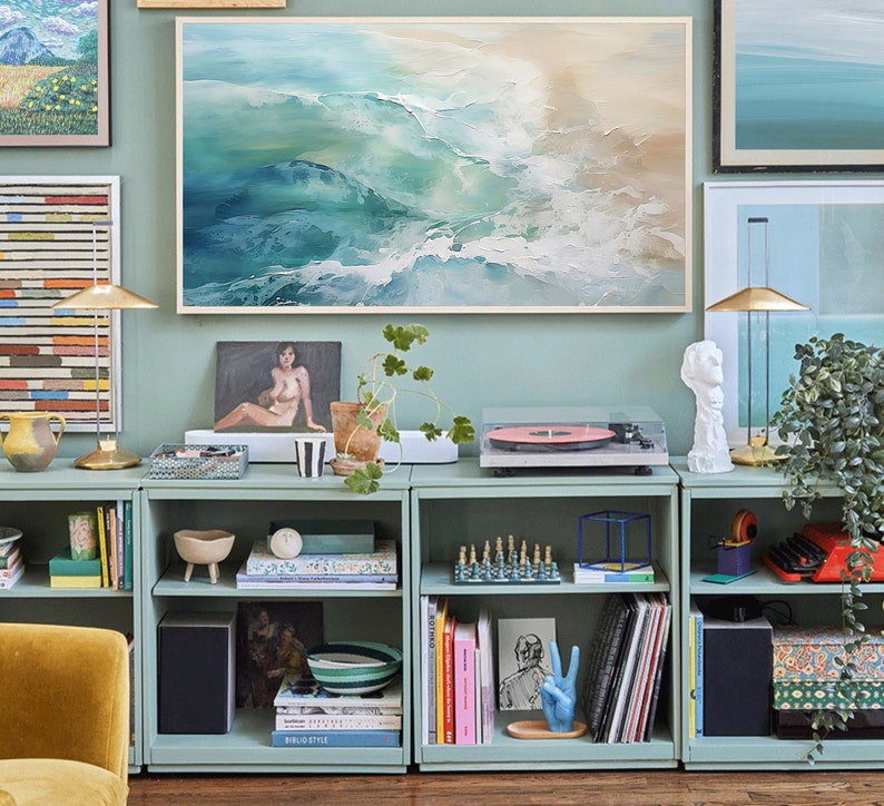 May include: A set of four teal blue bookshelves with various items on the shelves, including books, records, a record player, a plant, and decorative items. The shelves are against a light blue wall with artwork above them.