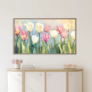 May include: A framed painting of a bouquet of pink, white, and yellow tulips with green leaves against a light blue background.