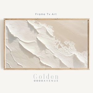 Op de afbeelding: Abstract schilderij in tinten wit en beige met een textuur, gelaagd effect. Het schilderij is ingelijst in een licht houten lijst. De tekst "Golden OOOOAVENUE" is onder het schilderij gedrukt.