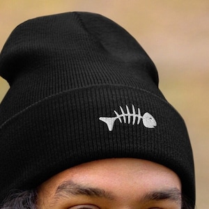 以下が含まれることがあります： 白い魚の骨の刺繍が施された黒いビーニー