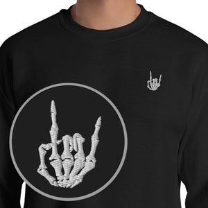 May include: Black sweatshirt with a white skeleton hand making the rock and roll sign. The hand is embroidered on the front of the sweatshirt in a circle. There is a smaller version of the hand embroidered on the right shoulder of the sweatshirt.