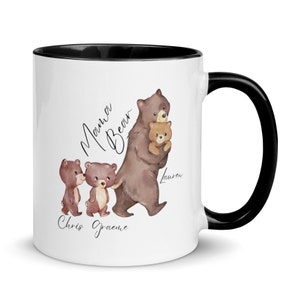 May include: White ceramic mug with a black rim and handle. The mug features a watercolor illustration of a mama bear and two cubs. The text "Mama Bear" is written in cursive above the bears. The names "Lauren", "Chris", and "Graeme" are written below the bears.