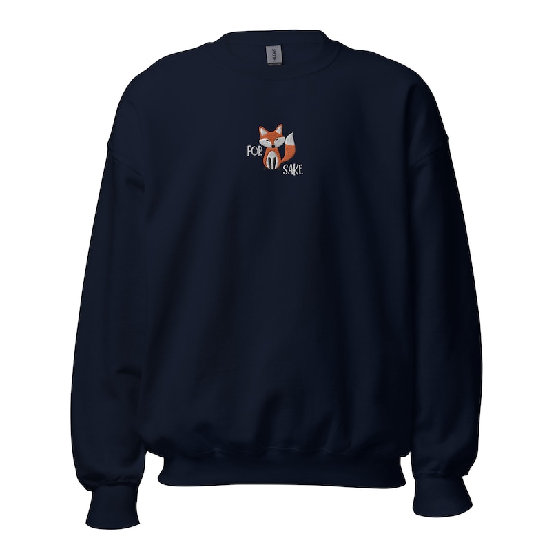 Pu&ograve; includere: Una felpa blu navy con una piccola volpe ricamata e il testo "FOR FOX SAKE" sul davanti.