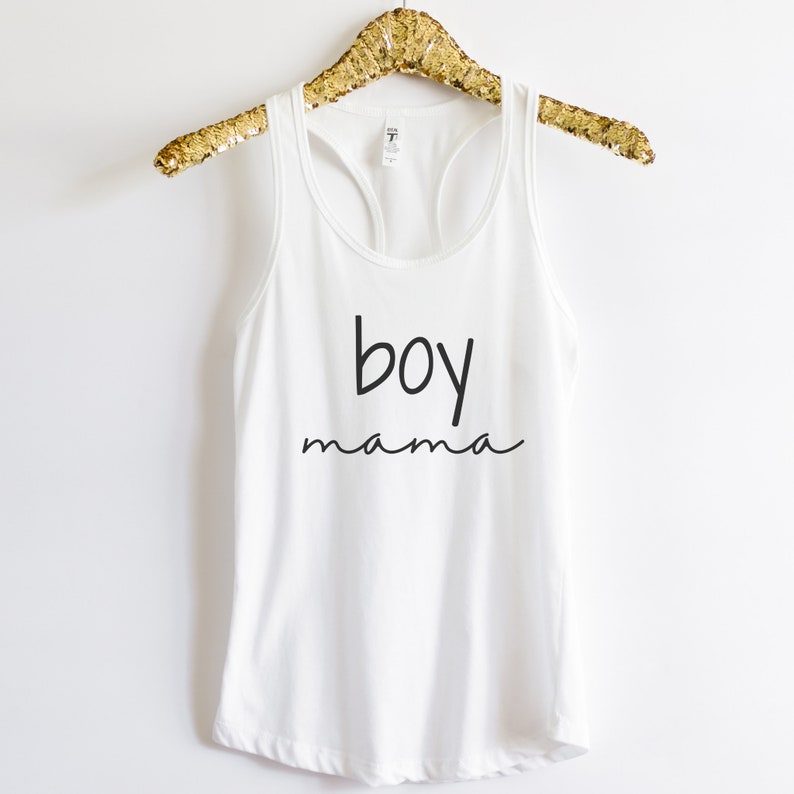 Puede incluir: Camiseta sin mangas blanca con las palabras "boy mama" impresas en escritura negra. La camiseta sin mangas est&aacute; colgada de una percha dorada con lentejuelas. Una camiseta informal y c&oacute;moda para el uso diario.