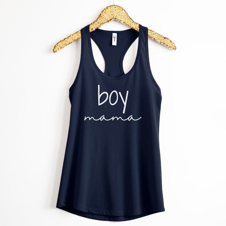 Puede incluir: Camiseta sin mangas azul marino con las palabras "boy mama" en escritura blanca. La camiseta sin mangas est&aacute; colgada de una percha dorada con lentejuelas sobre un fondo blanco. La parte superior tiene cuello redondo y espalda nadadora.