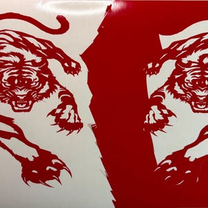 Könnte beinhalten: Ein Vinyl-Aufkleberbogen mit zwei identischen Tiger-Illustrationen in Sprungpose. Der linke Tiger ist rot auf weißem Hintergrund, während der rechte Tiger weiß auf rotem Hintergrund dargestellt ist, was ein kontrastreiches Design ergibt.