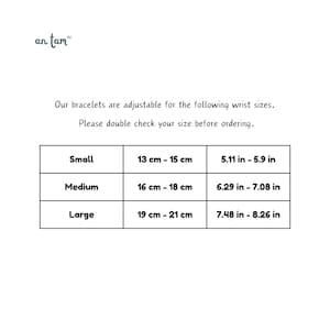 May include: White background with text and a table showing bracelet wrist sizes. The table includes sizes Small (13-15 cm), Medium (16-18 cm), and Large (19-21 cm). The brand name "an tam" is at the top.