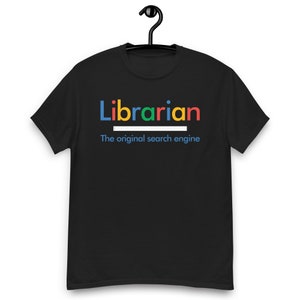 May include: Black t-shirt with the text "Librarian" in colorful letters and the phrase "The original search engine" below it.