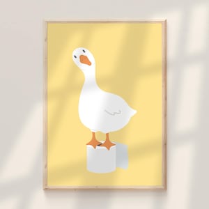 May include: A framed print featuring a cartoon goose standing on a roll of toilet paper. The goose is white with an orange beak and feet, set against a yellow background. The artwork has a minimalist style and is suitable for a bathroom or humorous decor.